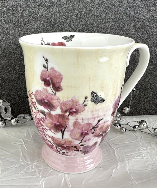 Krus med rosa Orkid&eacute; blomster og sommerfugl.
